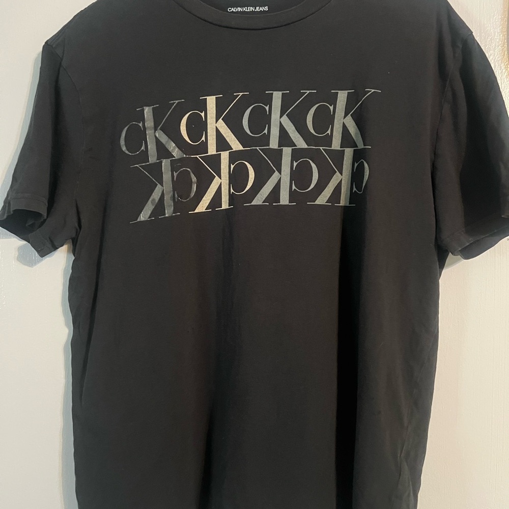 Calvin Klein Black Tee with Metallic Silver Logo Pattern